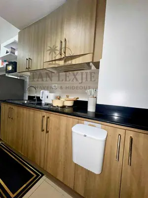 a kitchen with wooden cabinets and a toilet in it at Shore Residences by Tan LexJie in Manila