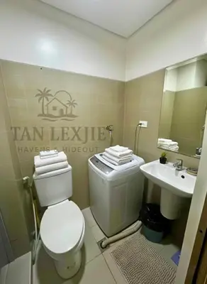 a bathroom with a toilet and a sink at Shore Residences by Tan LexJie in Manila