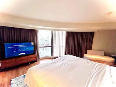 a hotel room with a bed and a flat screen tv at Hotel Residences - Novotel Suites Manila at Acqua in Manila