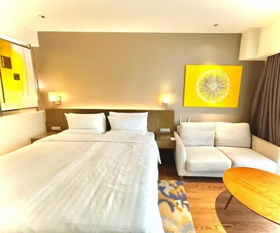 a hotel room with a bed and a couch at Hotel Residences - Novotel Suites Manila at Acqua in Manila