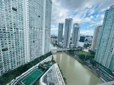 a view of a river in a city with tall buildings at Hotel Residences - Novotel Suites Manila at Acqua in Manila