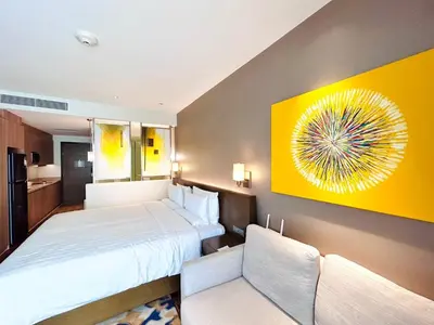 a hotel room with two beds and a yellow wall at Hotel Residences - Novotel Suites Manila at Acqua in Manila