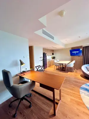 a living room with a wooden table and chairs at Hotel Residences - Novotel Suites Manila at Acqua in Manila