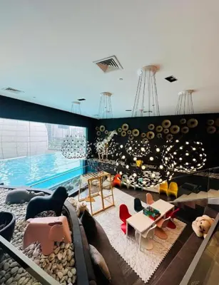 a living room with a swimming pool in a house at Cleo Suites at Novotel Hotel Residences near Makati in Manila