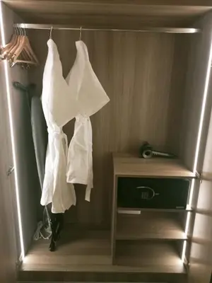a closet with white towels hanging on a rack at Cleo Suites at Novotel Hotel Residences near Makati in Manila