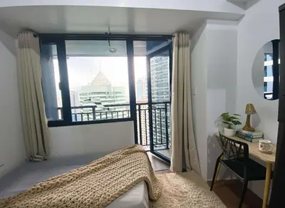 a bedroom with a large window with a view of a city at Air Residences 28F Balcony WiFi Netflix in Manila