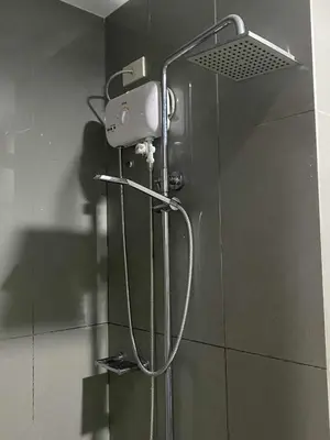 a shower in a bathroom with a shower head at Air Residences 28F Balcony WiFi Netflix in Manila