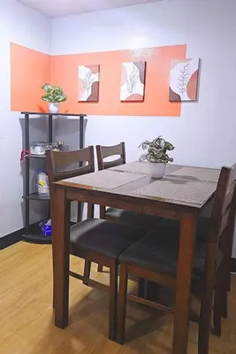 a dining room table and chairs in a room at Bright & Airy Loft Cambridge Village Charm in Cainta
