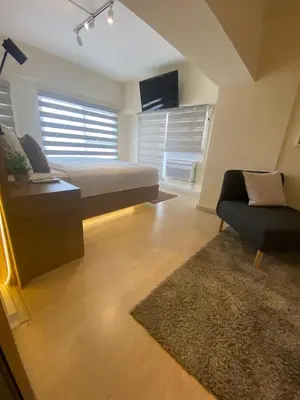 a bedroom with a bed and a couch and a chair at EDSA Heights Unit 3405 Cozy One Bedroom Penthouse Unit in Manila