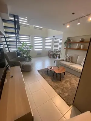 a living room with a couch and a table at EDSA Heights Unit 3405 Cozy One Bedroom Penthouse Unit in Manila