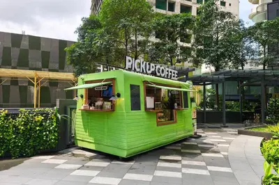 a green food truck parked in front of a building at Free Parking at Gramercy with Big TV and Fast WiFi in Manila