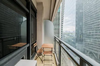 a balcony with two chairs and a view of a city at Free Parking at Gramercy with Big TV and Fast WiFi in Manila