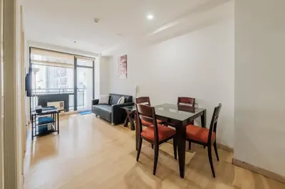 a living room with a table and chairs and a couch at Free Parking at Gramercy with Big TV and Fast WiFi in Manila