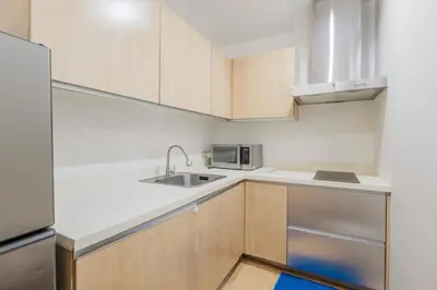 a kitchen with a sink and a microwave at Free Parking at Gramercy with Big TV and Fast WiFi in Manila