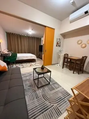 a living room with a couch and a bed and a table at One Uptown Residences, BGC, Taguig in Manila