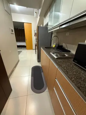 a kitchen with a counter and a dog bed in it at One Uptown Residences, BGC, Taguig in Manila