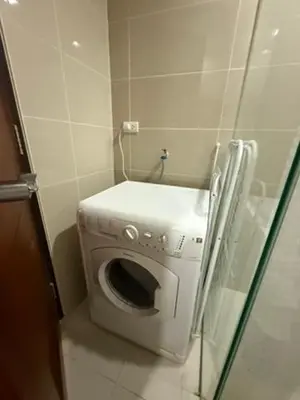 a washing machine in a corner of a bathroom at One Uptown Residences, BGC, Taguig in Manila