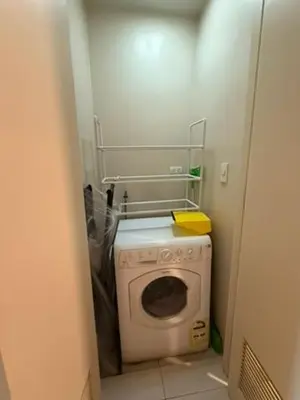 a small bathroom with a washing machine in a room at One Bedroom with Netflix at Uptown Residences, BGC, Taguig in Manila