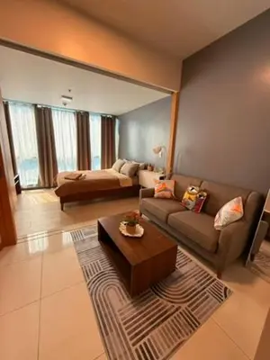 a living room with a couch and a coffee table at One Bedroom with Netflix at Uptown Residences, BGC, Taguig in Manila