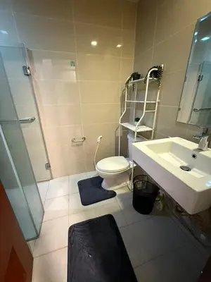 a bathroom with a toilet and a sink and a shower at One Bedroom with Netflix at Uptown Residences, BGC, Taguig in Manila