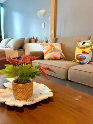 a living room with a table with a plant on it at One Bedroom with Netflix at Uptown Residences, BGC, Taguig in Manila