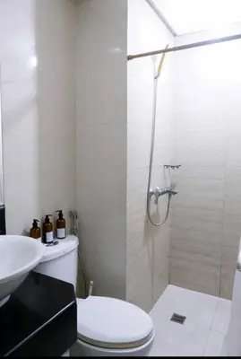 a bathroom with a shower and a toilet and a sink at 5A Southwing in Manila