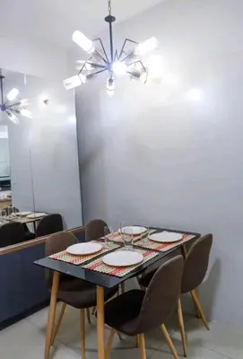 a dining room table with chairs and a ceiling fan at 5A Southwing in Manila