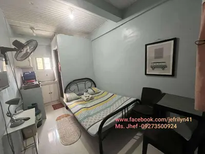 a small bedroom with a bed and a desk at Studio in the 2nd floor Transient Room with two wallfan in Manila