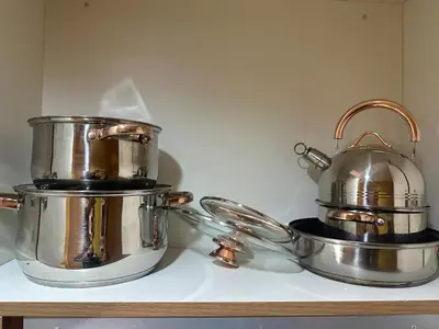 two silver pots and pans sitting on a counter at David's Cozy Home in Manila