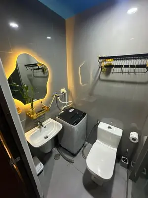 a bathroom with a white toilet and a sink at David's Cozy Home in Manila