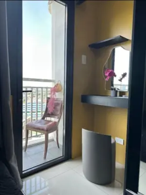 a mirror in a room with a chair on a balcony at David's Cozy Home in Manila