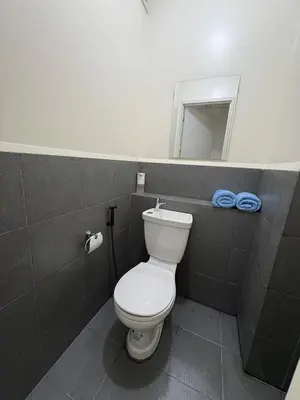 a bathroom with a white toilet and a mirror at Faith Studio Cubao in Manila