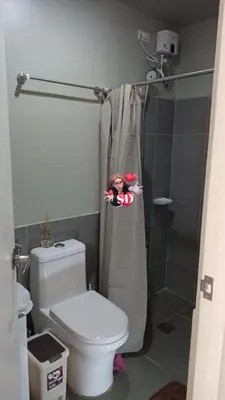 a bathroom with a shower with a doll in the shower curtain at Condotels Near Sucat Skyway in Manila