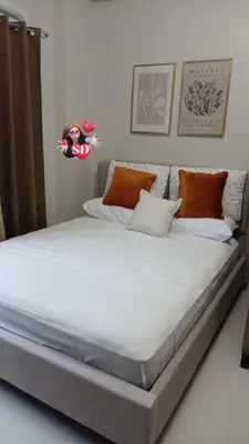 a large bed with white sheets and pillows at Condotels Near Sucat Skyway in Manila