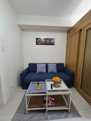 a living room with a blue couch and a table at J&W Homestay in Manila