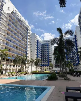 a swimming pool in front of a large building at Sea Residence 1BR unit 5 to 10 min walk to MOA by Angels Cozy Corner in Manila