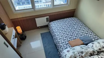 a small room with a bed and a window at Sea Residence 1BR unit 5 to 10 min walk to MOA by Angels Cozy Corner in Manila