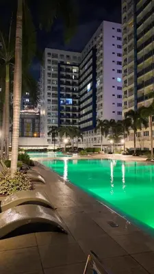 a pool with green water in a city at night at Sea Residence 1BR unit 5 to 10 min walk to MOA by Angels Cozy Corner in Manila