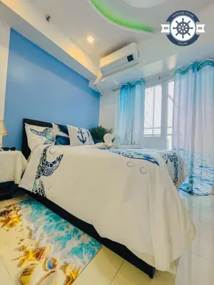 a bedroom with a large bed with blue walls at Cozy Condo with Balcony and Bay view plus PS4 at Taft Malate in Manila