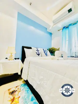 two beds in a room with blue walls at Cozy Condo with Balcony and Bay view plus PS4 at Taft Malate in Manila