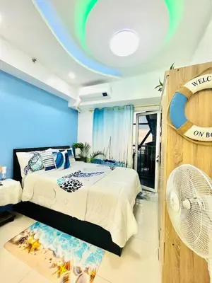 a bedroom with two beds and a blue wall at Cozy Condo with Balcony and Bay view plus PS4 at Taft Malate in Manila