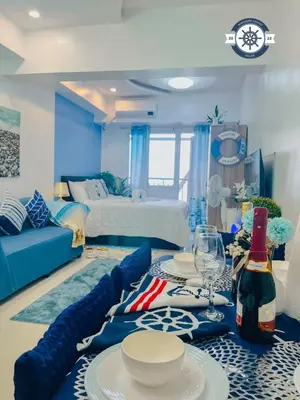 a living room with a table with plates and wine glasses at Cozy Condo with Balcony and Bay view plus PS4 at Taft Malate in Manila
