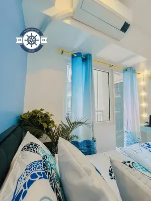 a bedroom with a bed with blue walls and a window at Cozy Condo with Balcony and Bay view plus PS4 at Taft Malate in Manila