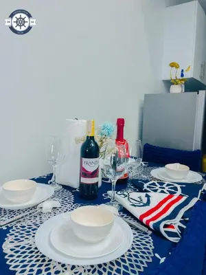a table with plates and a bottle of wine at Cozy Condo with Balcony and Bay view plus PS4 at Taft Malate in Manila