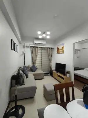 a living room with a couch and a bed at Condotels by San Antonio in Manila