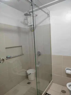 a bathroom with a glass shower with a toilet at Condotels by San Antonio in Manila