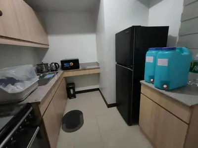 a kitchen with a black refrigerator and a sink at Condotels by San Antonio in Manila