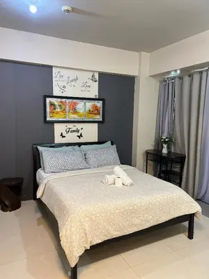 a bedroom with a bed with two towels on it at One Palm Tree Villas-Hyuna Place Across Naia T3 Manila in Manila