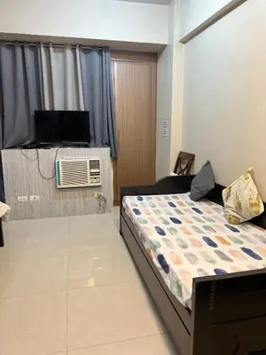 a bedroom with a bed and a tv in a room at One Palm Tree Villas-Hyuna Place Across Naia T3 Manila in Manila