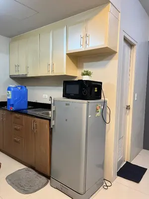 a kitchen with a microwave on top of a refrigerator at One Palm Tree Villas-Hyuna Place Across Naia T3 Manila in Manila